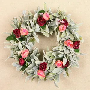 Détail d'une couronne de feuilles d'oreilles d'agneau avec roses roses et rouges