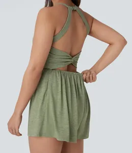 Close-up back view of a green sleeveless halter romper with twist detail and open back design