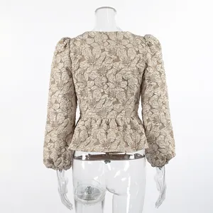 Vista posteriore dettagliata di un'elegante blusa jacquard con maniche a sbuffo e peplo