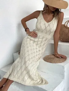 Detail of a chic cream hollow-out knit maxi dress for vacation and resort style.