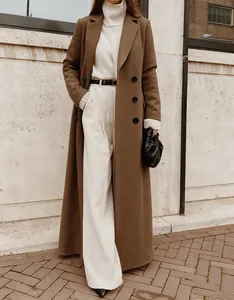 Elegant long brown wool coat styled with a white turtleneck and trousers for winter.