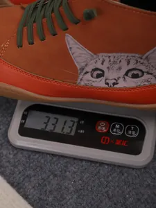 Detail van de gewichtsmeting van een hoge schoen met kattenprint op een weegschaal
