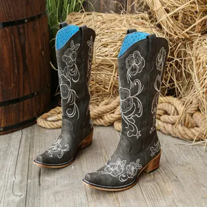 Détail de bottes western grises brodées avec doublure bleue