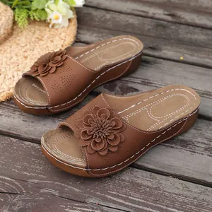 Elegant brown wedge sandals featuring a detailed flower and comfortable thick sole.