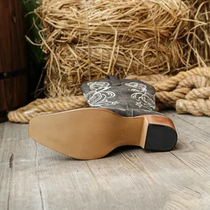 Vue détaillée de bottes western grises brodées avec bout pointu et talon moyen