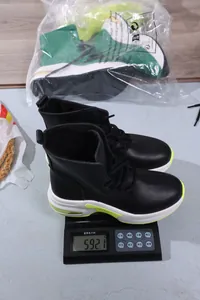 Gewichtsmessung zeigt 592,1g für diese schwarzen sportlichen Damenstiefel an.