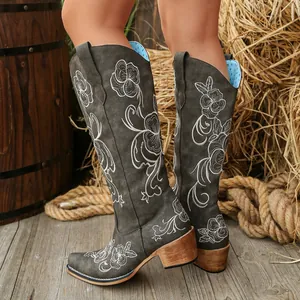 Détail de bottes Western grises brodées avec motifs floraux et talon carré stable