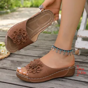 Detail of brown wedge slippers with flower decor and 4cm heel height measurement