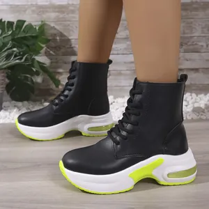 Detailansicht der schwarzen High-Top-Sportstiefel für Damen mit neongelben klobigen Sohlen.