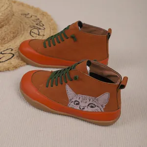 Detail van casual hoge schoenen met een schattige kattenprint en groene veters