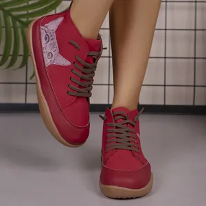 Detail van rode high-top vrijetijdsschoenen met schattige kattenprint en rubberen zool.