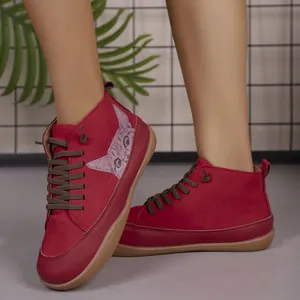 Detailweergave van rode hoge platte damesschoenen met kattenpatroon en bruine veters