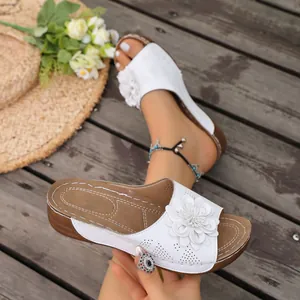 Detailed view of white summer wedge slippers with elegant 3D flower and laser-cut holes