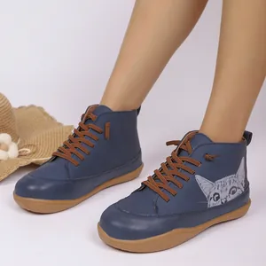 Detailopname van blauwe hoge platte schoenen met schattige kattenprint en bruine veters.