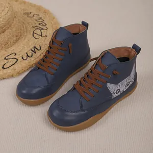 Gedetailleerde weergave van blauwe hoge schoenen met kattenprint en bruine veters