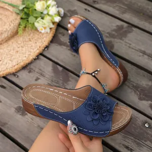 Detail view of navy blue summer wedge sandals featuring 3D floral embellishments.