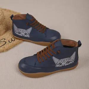 Detail van blauwe hoge damessneakers met een schattige kattenprint en bruine veters
