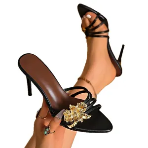 Eleganti sandali neri con tacco alto e un grande ornamento floreale in metallo
