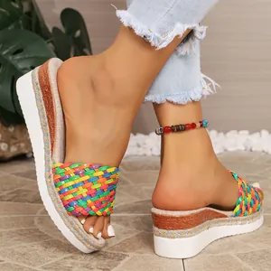 Vue détaillée de sandales ethniques à plateforme avec bride tissée colorée et corde.