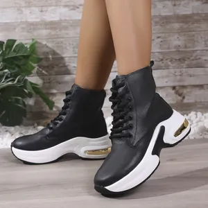 Detail der schwarzen PU-Leder-High-Top-Sportschuhe mit dicker weißer Sohle und Goldakzenten