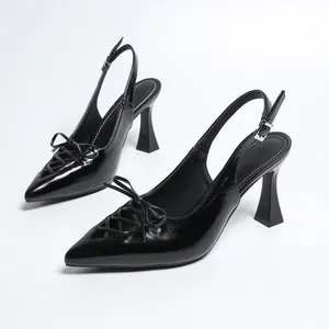 Elegantes zapatos de tacón destalonados negros con punta y detalle de lazo frontal