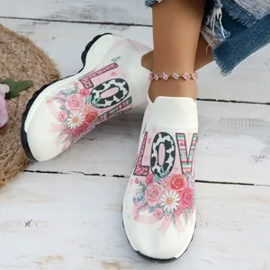 Vue détaillée de l'imprimé floral et de l'inscription LOVE sur des baskets en maille blanche