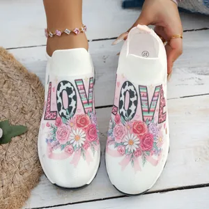 Vue détaillée de baskets blanches avec imprimé floral de roses et texte LOVE stylé