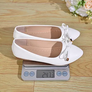 Detailed view of white pointed-toe flat shoes on a digital scale showing weight 247.3g