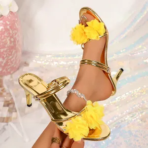 Close-up of gold high-heeled sandals with yellow floral decor and elegant kitten heels