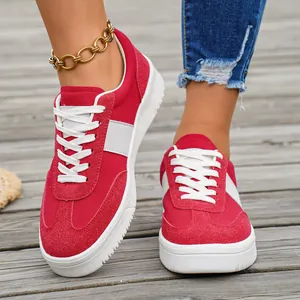 Chaussures de skate basses rouges et blanches pour femmes avec texture daim et semelles blanches.