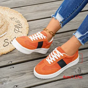 Détail de baskets compensées orange vif avec semelle de 4 cm portées par un mannequin