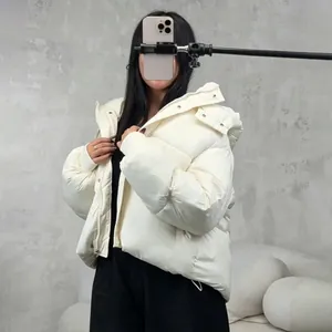 Upper body view showing the fit and hood of a white short puffer jacket on a female model