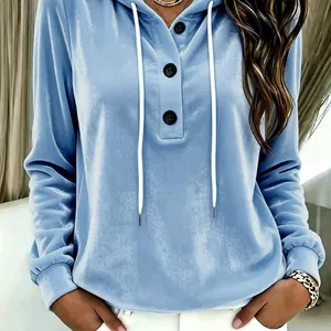 Close-up of women's blue velvet hoodie with drawstring hood and button neck.