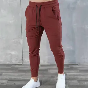 Detail view of burgundy men's fitness joggers with tapered legs and drawstring waist