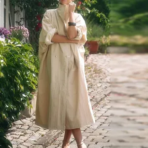 Elegant light apricot oversized trench coat with large lapels and double buttons