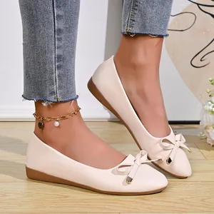 Elegant beige pointed toe flat shoes with bow detail and slip-on design.