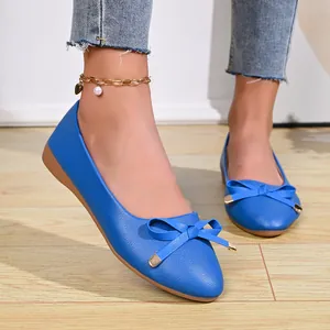 Detail shot of blue pointed-toe ballet flats with bow and pebble leather texture