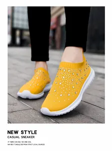 Primo piano di sneakers gialle traspiranti in maglia con eleganti decorazioni in strass.