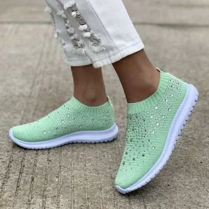 Primo piano di scarpe da ginnastica in maglia verde menta con strass scintillanti