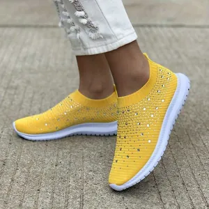 Vista dettagliata di scarpe da ginnastica gialle in tessuto fly-knit con strass brillanti