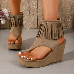 Détail exquis en gros plan de sandales compensées de style western à franges
