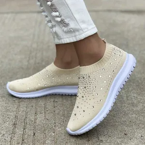Dettaglio di sneakers slip-on beige in maglia traspirante con strass scintillanti