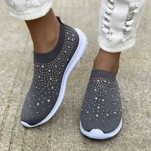 Dettaglio delle sneakers slip-on in maglia grigia traspirante con strass scintillanti