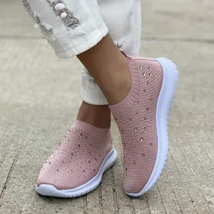 Dettaglio di scarpe da ginnastica rosa fly-knit con strass e suola bianca spessa