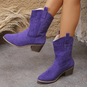 Close-up of purple suede western ankle boots with embroidery and chunky heels