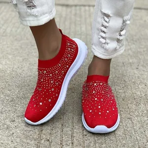 Primo piano dettagliato di sneakers in maglia rossa con decorazioni in strass luccicanti.
