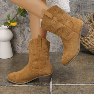 Detailed view of tan suede Western boots with elegant embroidery and chunky heels