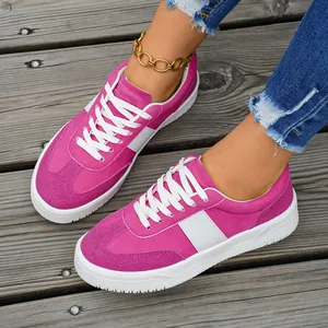 Baskets basses fuchsia élégantes pour femmes avec rayures blanches sur terrasse en bois