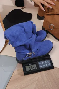 Detailed view of blue slouchy suede cowboy boots weighing 582.5g on a digital scale.