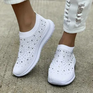 Primo piano di sneakers bianche in fly-knit traspirante con dettagli in strass lucidi
